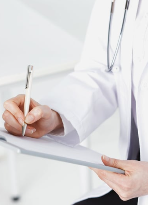Médica escribiendo en una carpeta clínica